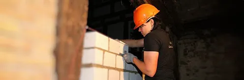 Eine junge Frau mauert eine Wand